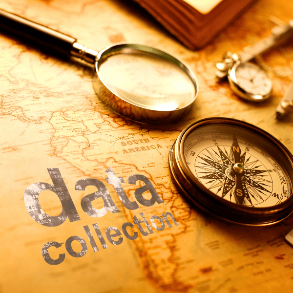 羅針盤が置かれた古地図と、「data collection」の文字が記された革のプレート。