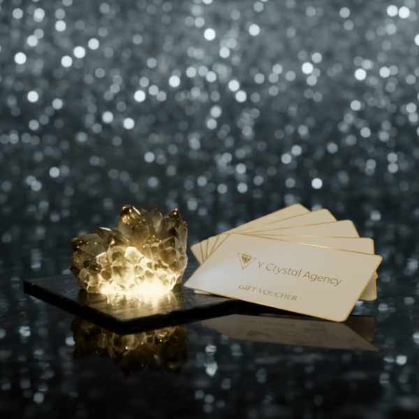 温かみのある光のオブジェと、Yクリスタル探偵社のロゴ入りギフト券の束。地域密着型プランの充実した特典内容を表現した画像。